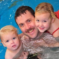 family swimming to built water confidence