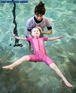 A child learning to float in swimming lessons in Wimbledon
