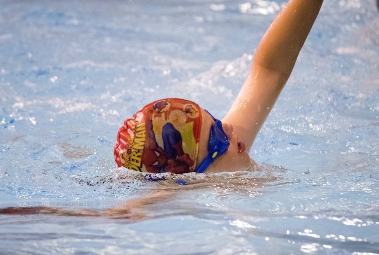 A child is swimming front crawl at blue wave swim School in London