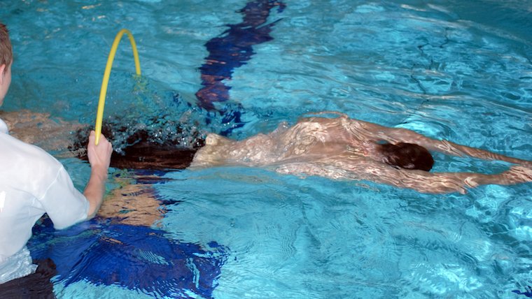 An adult learning to float in a swim lesson
