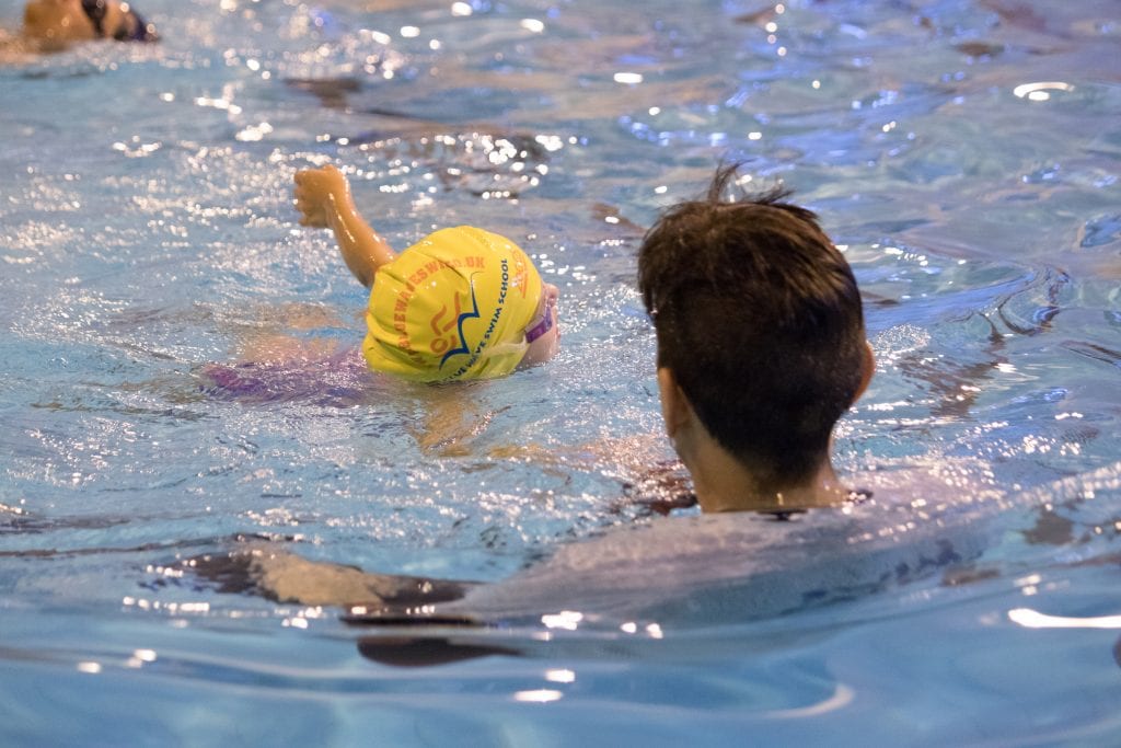 A child learning to swim front crawl confidently at Blue Wave Swim School