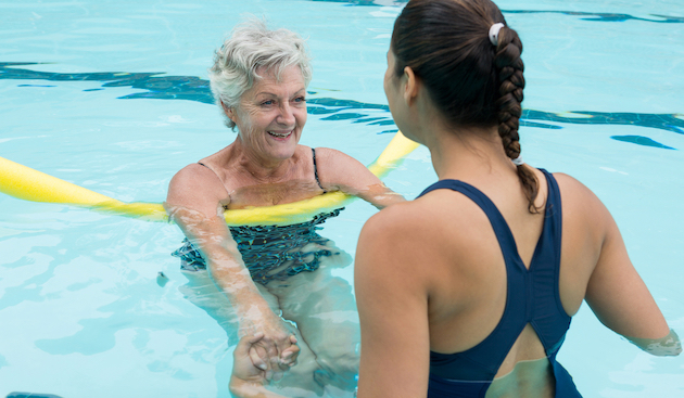 nervous adult swimmer with a teacher in a pool